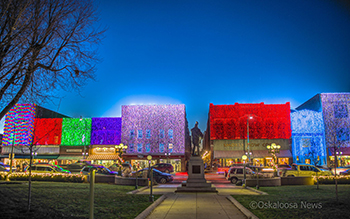 A view of downtown Oskaloosa during their annual painting with lights display where the fronts of buildings are illuminated with holiday lights.
